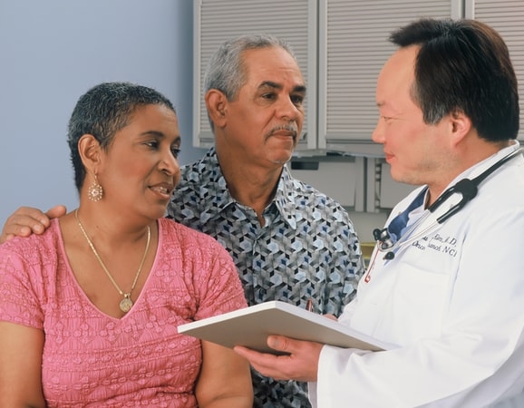 doctor consulting with patient and spouse