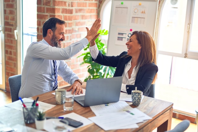 man and woman high fiving in a business setting